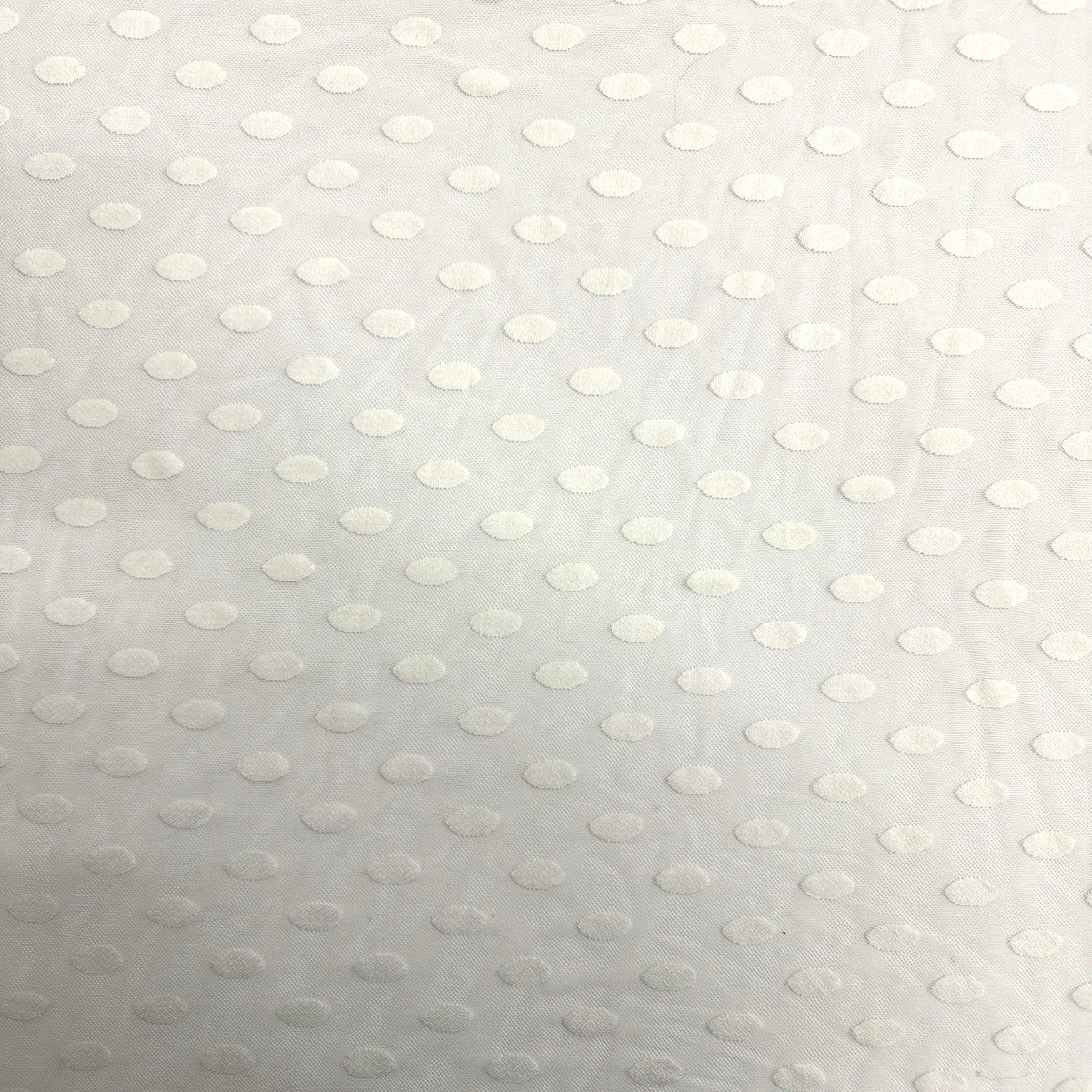 Tela de malla de lunares flocados en color marfil