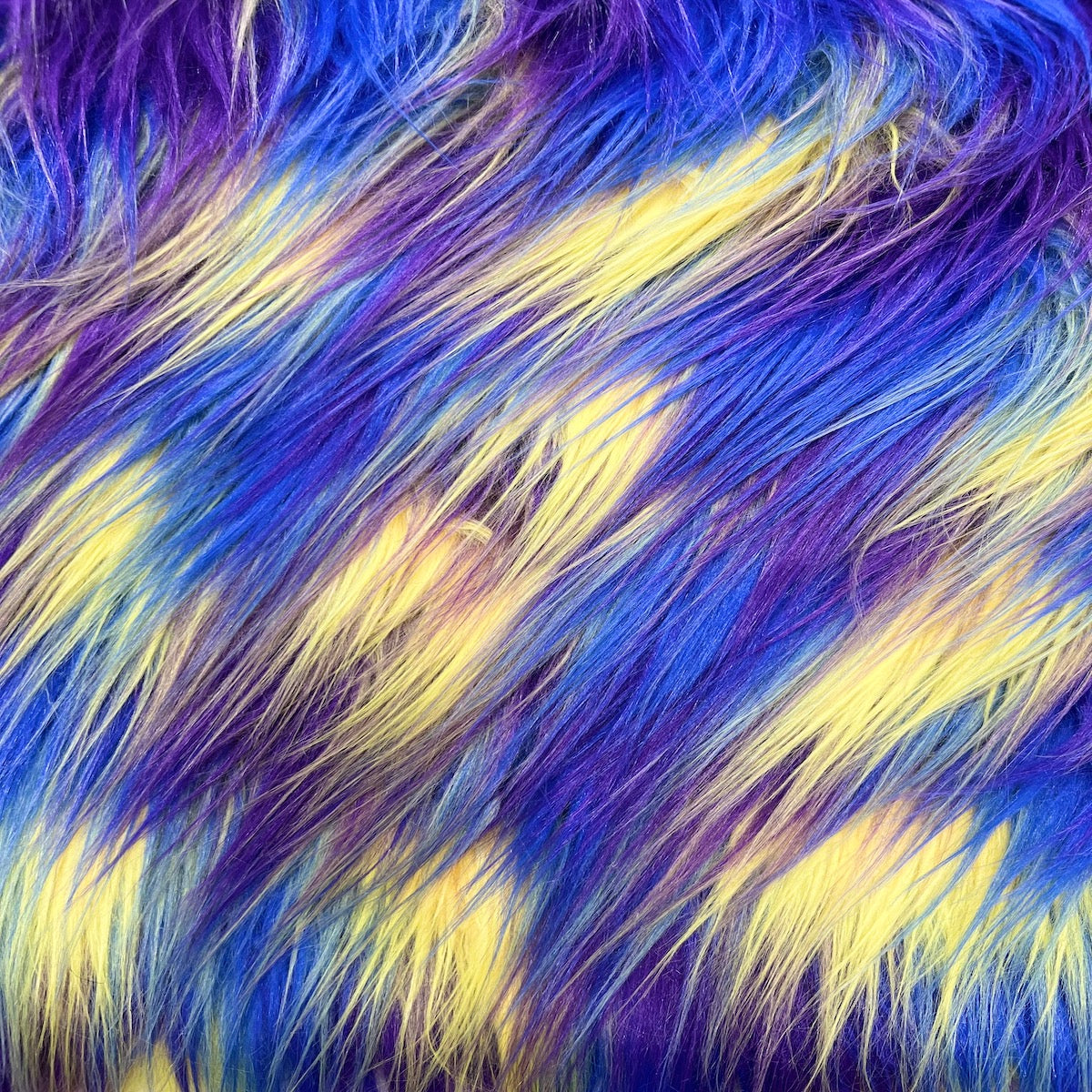 Tela de piel sintética lanuda de tres tonos, azul, amarillo, morado
